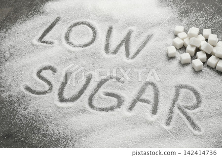 Composition with phrase LOW SUGAR on grey table Composition with phrase LOW SUGAR on grey table 142414736