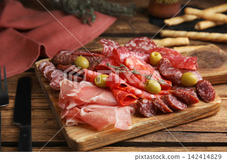 Tasty prosciutto with other delicacies served on wooden table Tasty prosciutto with other delicacies served on wooden table 142414829