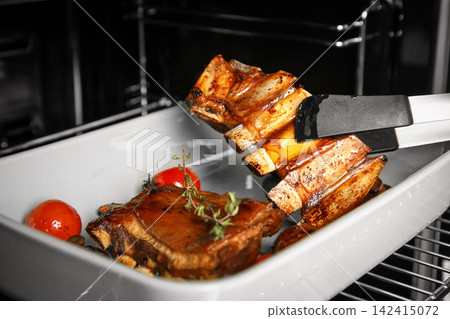 Delicious roasted ribs in oven, closeup. Yummy meat 142415072