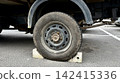 Vehicle wheel secured with bricks on asphalt parking lot 142415336