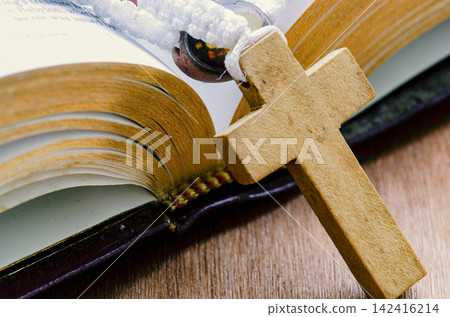 Close up view of wooden Holy Cross and Holy Bible with customizable space for text. Religion concept. 142416214