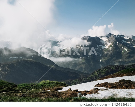 Dramatic alpine panorama from the Mindelheim Via Ferrata in the Allgaeu Alps, Germany, partially snow covered mountain slopes and rugged peaks emerging through clouds, cinematic adventure travel Dramatic alpine panorama from the Mindelheim Via Ferrata in the Allgaeu Alps, Germany, partially snow covered mountain slopes and rugged peaks emerging through clouds, cinematic adventure travel 142416435