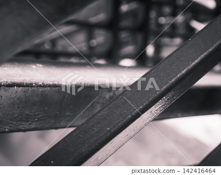 Minimalist black and white close-up of a dark metallic structure and diagonal steel beams. Minimalist black and white close-up of a dark metallic structure and diagonal steel beams. 142416464