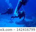 Scuba divers swimming in the blue ocean 142416799