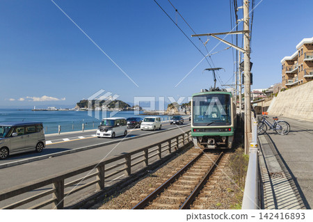 湘南鎌倉高中站:美麗的藍天、江之島和江之電列車。 湘南鎌倉高中站:美麗的藍天、江之島和江之電列車。 142416893