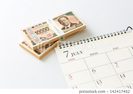 一份七月的日曆和一疊現金 一份七月的日曆和一疊現金 142417482