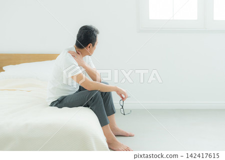 Middle-aged men struggling with bed-related issues Middle-aged men struggling with bed-related issues 142417615