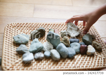 Stones on rattan and children's hands Stones on rattan and children's hands 142417739