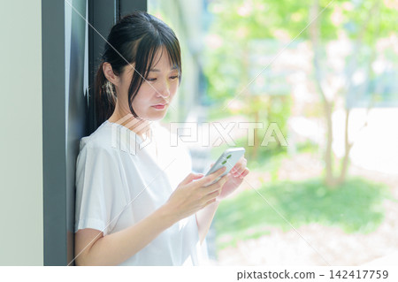 A female nurse using a smartphone A female nurse using a smartphone 142417759