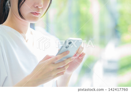 A female nurse using a smartphone A female nurse using a smartphone 142417760