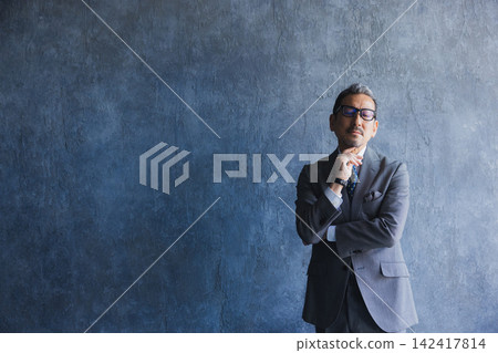 A man in a suit wearing glasses A man in a suit wearing glasses 142417814
