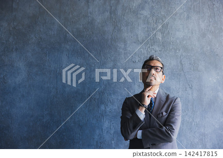 A man in a suit wearing glasses A man in a suit wearing glasses 142417815