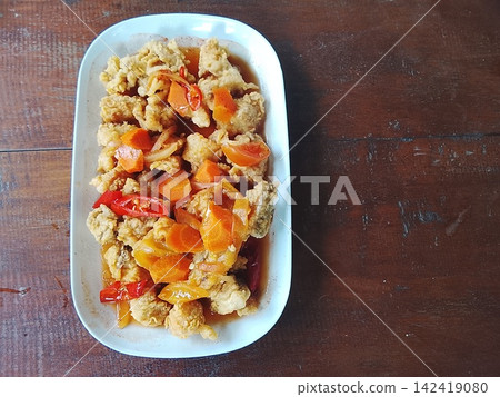 Sweet and sour chicken with crispy skin and carrots on a white plate with copy space top view Sweet and sour chicken with crispy skin and carrots on a white plate with copy space top view 142419080