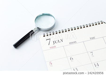 July calendar and magnifying glass July calendar and magnifying glass 142420956