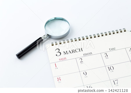 March calendar and magnifying glass March calendar and magnifying glass 142421128