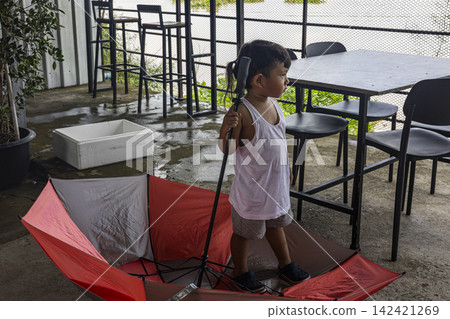 Asian Toddler Playing With Red Umbrella Asian Toddler Playing With Red Umbrella 142421269