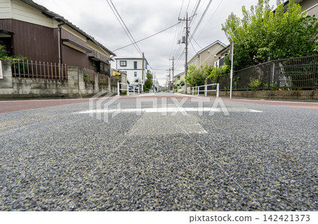低角度拍攝的道路箭頭標記和居民區。 低角度拍攝的道路箭頭標記和居民區。 142421373