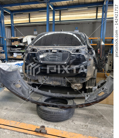 Damaged car undergoing rear bumper repair in workshop 142421717