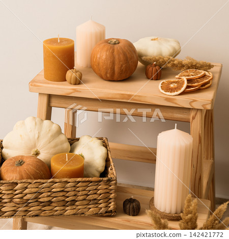 Candles and pumpkins in box on wooden shelves on white backgroun 142421772