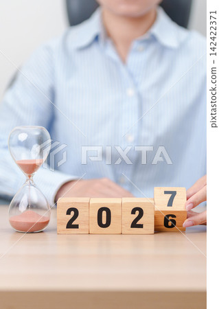 2026 end year to Happy New Year 2027 with hourglass on table. Resolution, time, plan, goal, motivation, reboot, countdown and New Year holiday concepts 142422371
