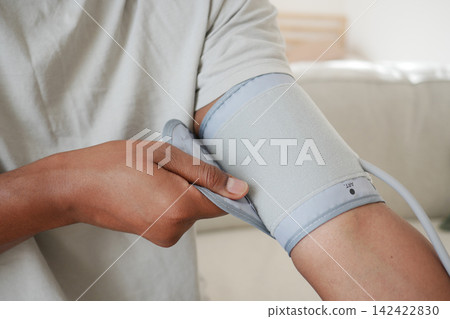 Measuring blood pressure at home in a living room Measuring blood pressure at home in a living room 142422830
