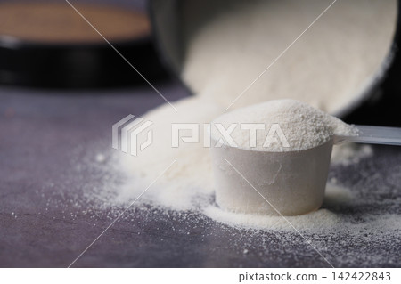 Powder pouring from a container with a scoop Powder pouring from a container with a scoop 142422843