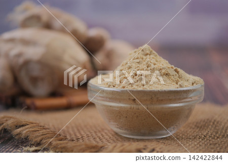 Ginger powder in clear bowl on rustic table Ginger powder in clear bowl on rustic table 142422844