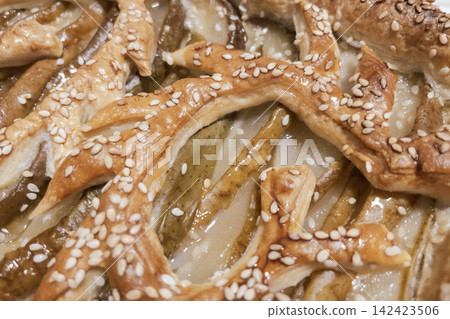 Top view close-up of baked pear puff pastry tart with sesame lattice pattern Top view close-up of baked pear puff pastry tart with sesame lattice pattern 142423506
