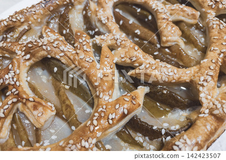 Top view close-up of baked pear puff pastry tart with sesame lattice pattern Top view close-up of baked pear puff pastry tart with sesame lattice pattern 142423507