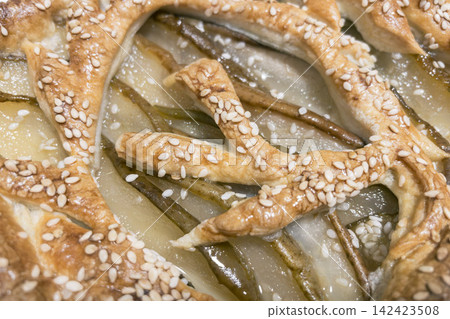 Top view close-up of baked pear puff pastry tart with sesame lattice pattern Top view close-up of baked pear puff pastry tart with sesame lattice pattern 142423508