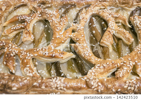 Top view close-up of baked pear puff pastry tart with sesame lattice pattern Top view close-up of baked pear puff pastry tart with sesame lattice pattern 142423510