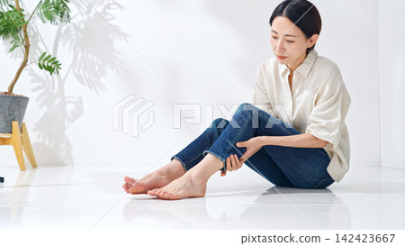 一位女士正在撫摸自己的雙腳。疼痛、肌肉疼痛、疲勞、精疲力竭、小腿疼痛、關節疼痛、按摩、足部護理、放鬆。 一位女士正在撫摸自己的雙腳。疼痛、肌肉疼痛、疲勞、精疲力竭、小腿疼痛、關節疼痛、按摩、足部護理、放鬆。 142423667
