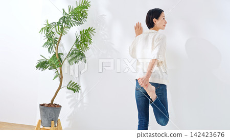 一位中年婦女伸展雙腿。健康、醫療保健、健康生活、身體照護、休閒、生活方式 一位中年婦女伸展雙腿。健康、醫療保健、健康生活、身體照護、休閒、生活方式 142423676