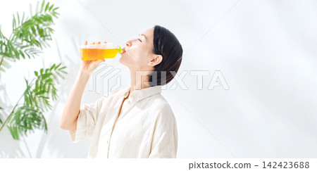 一位女士正在喝瓶裝茶。補水、烏龍茶、綠茶、紅茶、大麥茶、補水、飲料、果汁 一位女士正在喝瓶裝茶。補水、烏龍茶、綠茶、紅茶、大麥茶、補水、飲料、果汁 142423688