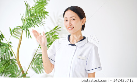 A woman in a white coat talking. Nurse, caregiver, interview, examination, medical treatment, consultation, interview, medical history taking, reporting, explanation, medical office work. A woman in a white coat talking. Nurse, caregiver, interview, examination, medical treatment, consultation, interview, medical history taking, reporting, explanation, medical office work. 142423712