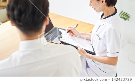 A woman in a white coat conducting a medical interview. Nurse, doctor, industrial physician, consultation, interview, examination, medical treatment, health checkup, reception, clinic, pharmacist A woman in a white coat conducting a medical interview. Nurse, doctor, industrial physician, consultation, interview, examination, medical treatment, health checkup, reception, clinic, pharmacist 142423729