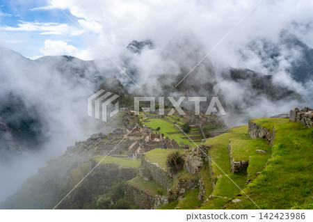Panoramic view of Machu Picchu ruins surrounded by misty mountains, Peru Panoramic view of Machu Picchu ruins surrounded by misty mountains, Peru 142423986