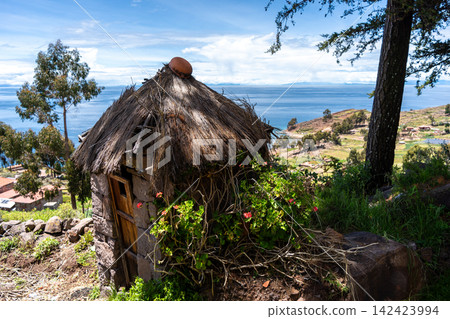 Traditional huts overlooking Lake Titicaca on Taquile Island, Peru 142423994