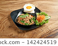 Thai street food on black dish with fried egg and fish sauce  Kao Pad Kapao 142424519