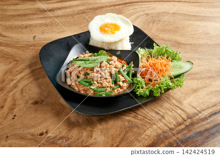 Thai street food on black dish with fried egg and fish sauce  Kao Pad Kapao 142424519