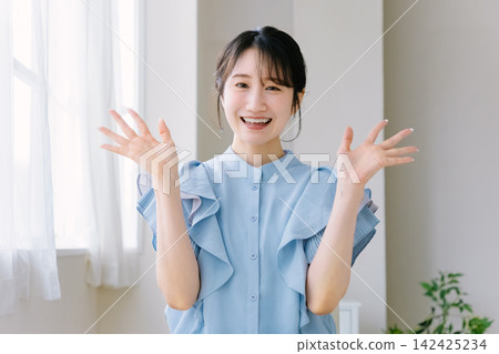 年輕女子微笑著揮手 年輕女子微笑著揮手 142425234