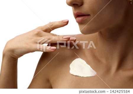 Woman applies body cream to chest and collarbone Woman applies body cream to chest and collarbone 142425584
