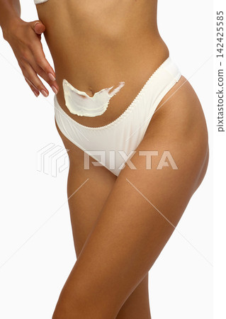 Female body with moisturizer applied above bikini line Female body with moisturizer applied above bikini line 142425585