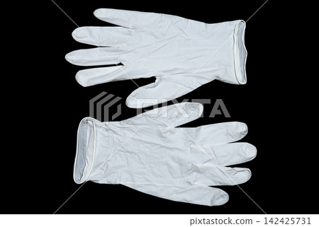 Pair of white latex gloves on a dark background Pair of white latex gloves on a dark background 142425731