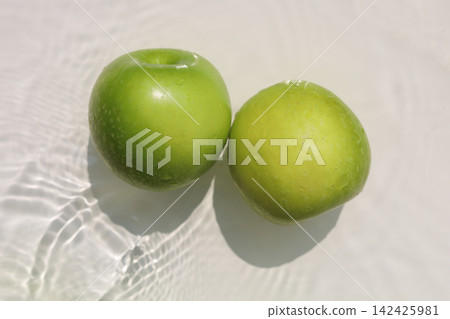 Fresh green apples floating in clear rippling water. Fresh green apples floating in clear rippling water. 142425981