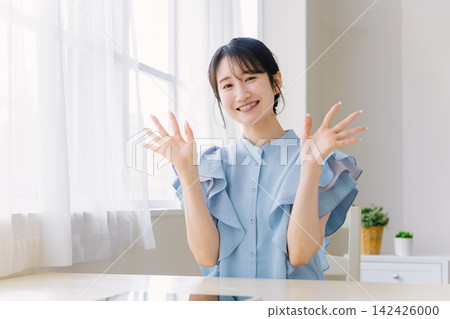 年輕女子微笑著揮手 年輕女子微笑著揮手 142426000