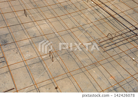 A section of a concrete road cut open and prepared with steel wire mesh rebar for repair work. A section of a concrete road cut open and prepared with steel wire mesh rebar for repair work. 142426078