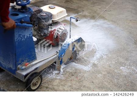 A walk-behind concrete cutter machine, concrete cutter blade spinning with water. 142426249