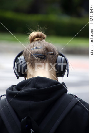 Woman in the steet with headphones 142426472