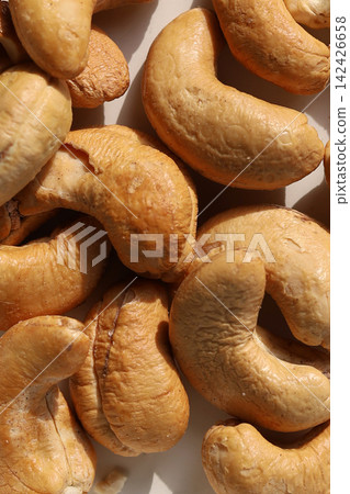 Roasted cashew nuts on a white background. Roasted cashew nuts on a white background. 142426658